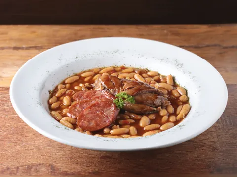 Cassoulet com feijão branco e linguiça servido em panela de barro